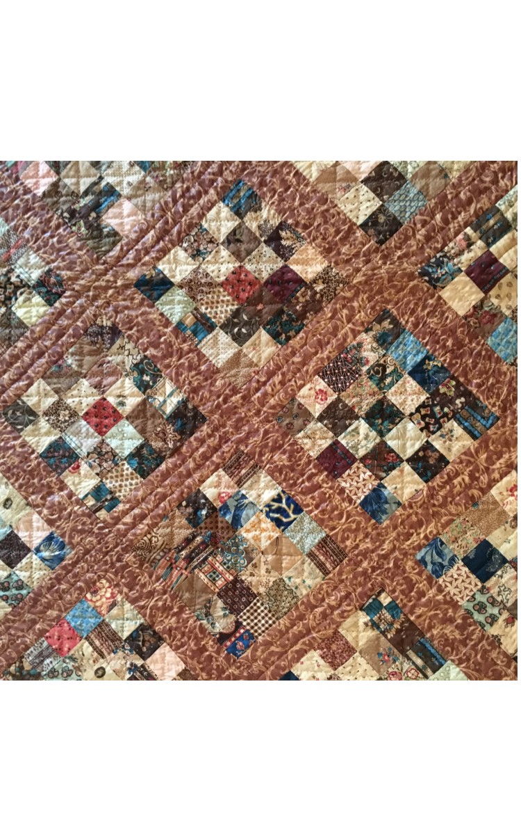 <h3>TWENTY-FIVE PATCH VARIATION</h3>
<br>
<p><strong>Pieced Quilt</strong></p>
<p><strong>Mid-nineteenth century</strong></p>
<p><strong>Gift of Frieda Petrey</strong></p>
<br>
<p>This recently-acquired quilt was made by either a member of the
Terry family or the Latham family – both old Orient families –
and was passed down in that family for many generations. The
pattern is straightforward. It consists of forty full blocks each
made up of twenty-five small square pieces of printed cotton. On
the edges there are another twenty partial blocks. As all the blocks
in the quilt are set on the diagonal (set on point), these partial
blocks form triangles. All the blocks are separated by a grid, or
sashing, of a handsome brown fabric.</p>
<br>
<p>The sheer number of various printed cottons that make up this
quilt is astonishing. There are 1000 squares of various printed
cotton designs in the forty blocks, and another 300 squares or
triangles in the partial blocks. The squares within each block are
mostly arranged so that light and dark fabric squares alternate.
However this is not uniformly the case. Is this the “deliberate
mistake” common in quilt making? The quilt is at least 175 years
old and is in excellent condition.</p>