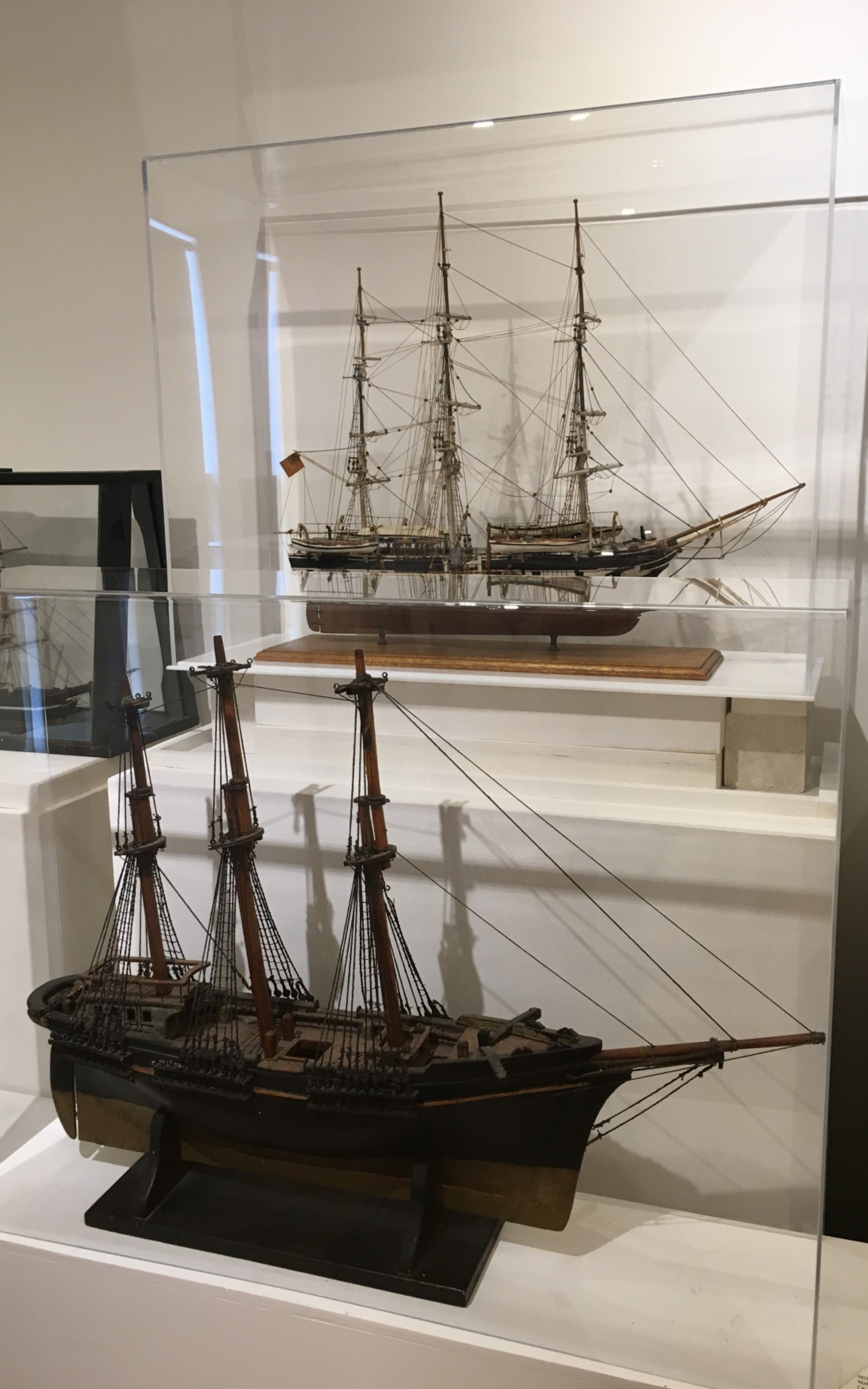 <h3>MODEL OF THE <em>CHARLES W. MORGAN</em></h3>
<br>
<p><strong>Attributed to Wiliam Conklin</strong></p>
<p><strong>1900?</strong></p>
<br>
<p>The Charles W. Morgan is the last ship of an American whaling fleet that numbered
more than 2700 vessels. She was built in 1841 in New Bedford, Massachusetts, and
measures 106 feet 11 inches on deck; her beam measures 27 feet, 9 inches. Over an
extraordinarily long eighty-year whaling career, she made thirty-seven voyages –
most lasting at least three years. The Charles W. Morgan’s whaling days ended in
1921, and since 1941 she has been at Mystic Seaport in Connecticut. After a major
restoration, the Charles W. Morgan made her thirty-eighth voyage in 2014 around
New England ports. This model shows her crew cutting in a whale; the large strip of
blubber would be boiled in the trypots on the forward deck to produce whale oil.</p>
<br>
</p>The Charles W. Morgan is the last ship of an American whaling fleet that numbered
more than 2700 vessels. She was built in 1841 in New Bedford, Massachusetts, and
measures 106 feet 11 inches on deck; her beam measures 27 feet, 9 inches. Over an
extraordinarily long eighty-year whaling career, she made thirty-seven voyages –
most lasting at least three years. The Charles W. Morgan’s whaling days ended in
1921, and since 1941 she has been at Mystic Seaport in Connecticut. After a major
restoration, the Charles W. Morgan made her thirty-eighth voyage in 2014 around
New England ports. This model shows her crew cutting in a whale; the large strip of
blubber would be boiled in the trypots on the forward deck to produce whale oil.</p>
<br>
<h3>MODEL OF A THREE MASTED SHIP</em></h3>
<br>
<p><strong>Maker unknown</strong></p>
<p><strong>Ca. 1900?</strong></p>
<br>
<p>This seems to be an unfinished model of an unidentified ship as the three masts have
no yards to hold the sails. Although a well-constructed model, there are condition
problems as well with this model.</p>

